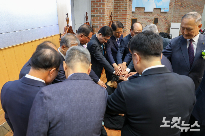 김제세계선교회(GSM) 관계자들과 참석자들이 캄보디아로 파송되는 이계절·이강애 선교사 부부를 위해 기도하고 있다. 최화랑 기자