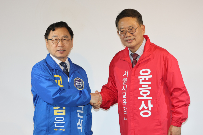 서울시교육감에 출마하는 정근식 후보(왼쪽)와 윤호상 후보가 20일 서울 종로구 종로문화공간온에서 공동선언문을 발표, 악수하고 있다. 연합뉴스