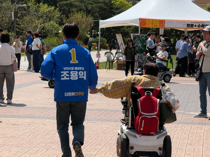 조용익 부천시장 후보가 직접 발로 뛰며 한 장애인과 동행하고 있는 모습. 조용익 캠프 제공
