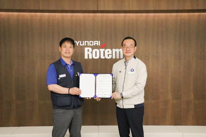 김익수(오른쪽) 현대로템 경영지원본부장과 남봉희 전국금속노동조합 현대로템 지회장이 19일 현대로템 창원공장에서 열린 동반성장 노사미래전략TFT 발족식에서 기념촬영을 하고 있다. 현대로템 제공