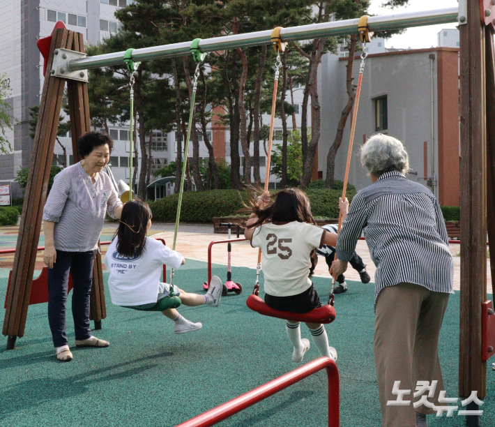 어르신들이 그네를 밀어주고 있다. 임성민 기자