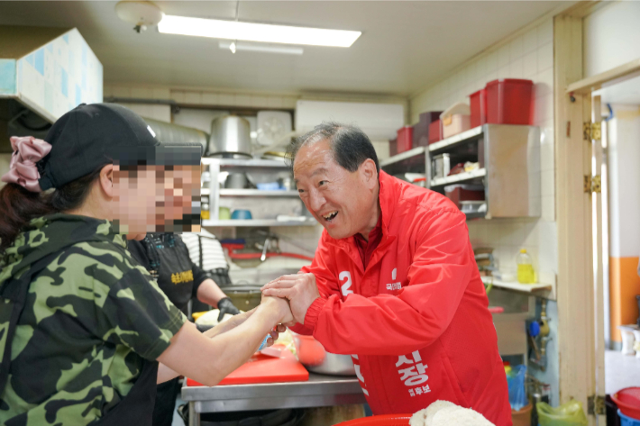 상인들과 얘기를 나누며 악수를 하고 있는 국민의힘 이병선 속초시장. 이 후보 페이스북 캡처