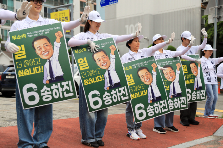선거운동원들이 무소속 송하진 여수시의원 후보의 캐리커처가 그려진 홍보물을 들고 유세를 벌이고 있다. 송하진 제공