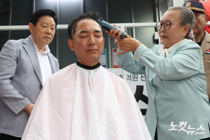 6.3지방선거와 국회의원 재보궐선거 공식 선거운동 첫 날인 21일 부산 북구 구포시장 앞에서 박민식 국민의힘 부산 북구갑 국회의원 보궐선거 후보가 삭발을 하고 있다.