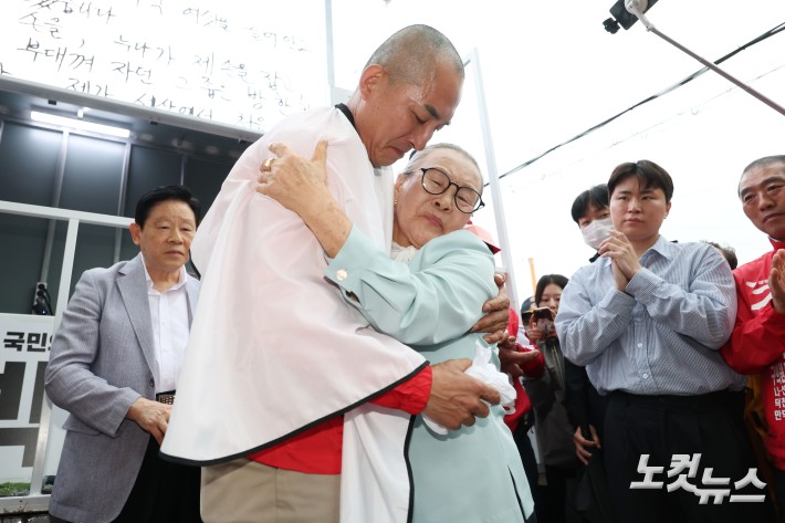 6.3지방선거와 국회의원 재보궐선거 공식 선거운동 첫 날인 21일 부산 북구 구포시장 앞에서 박민식 국민의힘 부산 북구갑 국회의원 보궐선거 후보가 삭발을 한 후 어머니와 포옹을 하고 있다.