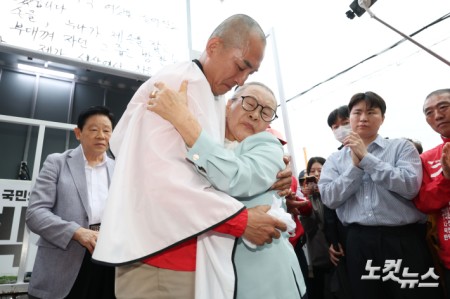 6.3지방선거와 국회의원 재보궐선거 공식 선거운동 첫 날인 21일 부산 북구 구포시장 앞에서 박민식 국민의힘 부산 북구갑 국회의원 보궐선거 후보가 삭발을 한 후 어머니와 포옹을 하고 있다.