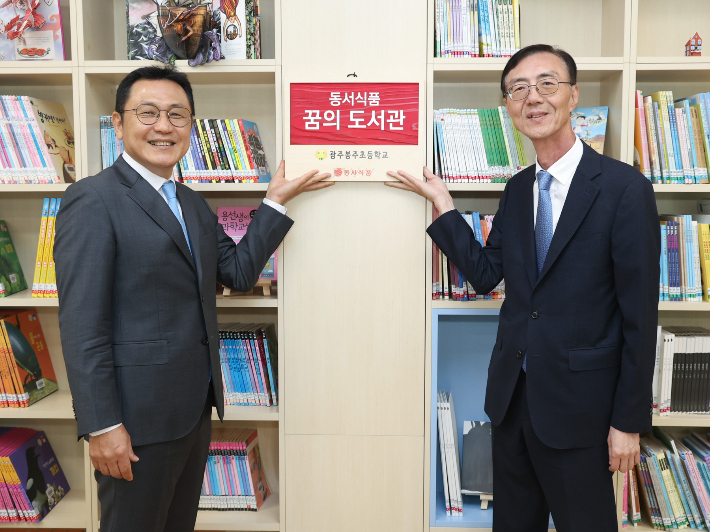 지난달 29일 광주봉주초등학교에서 진행된 '제10회 동서식품 꿈의 도서관' 도서 기증식에서 광주봉주초등학교 김태선(왼쪽) 교장과 동서식품 최상인 홍보상무가 기념촬영을 하고 있다. 동서식품 제공