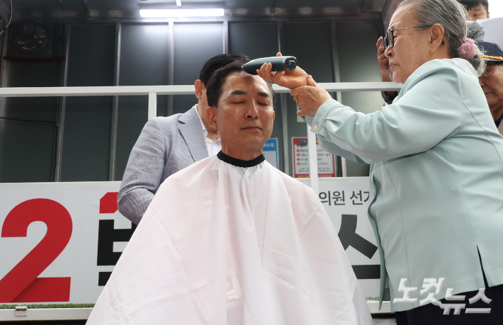 6·3지방선거와 국회의원 재보궐선거 공식 선거운동 첫 날인 21일 부산 북구 구포시장 앞에서 박민식 국민의힘 부산 북구갑 국회의원 보궐선거 후보가 삭발을 하고 있다. 류영주 기자