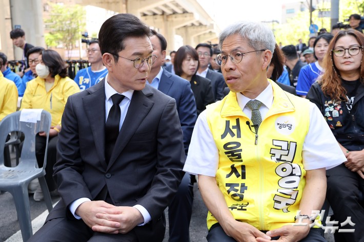 더불어민주당 정원오 서울시장 후보와 정의당 권영국 서울시장 후보가 22일 서울 광진구 지하철 2호선 구의역에서 열린 구의역 참사 10주기 추모문화제에 참석해 대화를 하고 있다.
