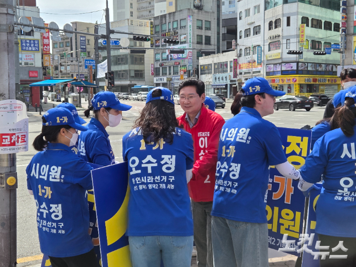 국민의힘 이상일 용인시장 후보가 22일 오전 선거 유세를 마친 뒤 더불어민주당 선거운동원들과 인사를 나누고 있다. 정성욱 기자