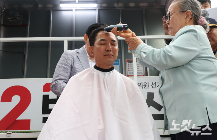 6.3지방선거와 국회의원 재보궐선거 공식 선거운동 첫 날인 21일 부산 북구 구포시장 앞에서 박민식 국민의힘 부산 북구갑 국회의원 보궐선거 후보가 삭발을 하고 있다. 부산=류영주 기자