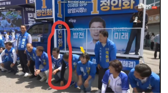 정인화 광양시장 후보(빨간색 동그라미) 등 더불어민주당 지방선거 후보들이 24일 광양 옥곡5일장 유세 중 진행자의 지시에 따라 앉았다 일어나기를 하고 있다. 박필순 광양시장 후보 SNS 캡처