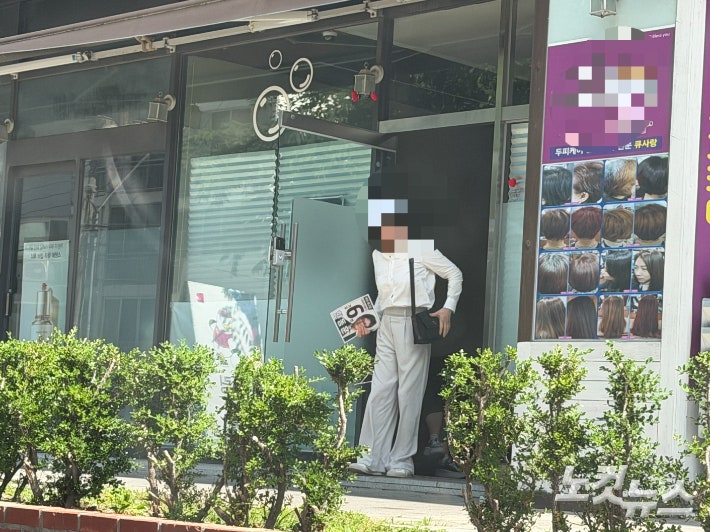 한동훈 후보를 지지하는 자원봉사자가 24일 부산 북구 덕천동 소재 자원봉사자 쉼터로 불리는 사무실에서 나오고 있다. 이정주 기자