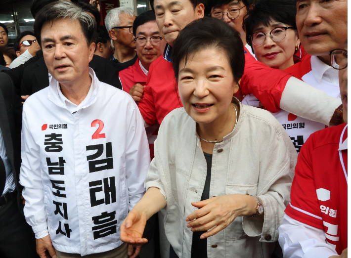 박근혜 전 대통령이 25일 오후 국민의힘 김태흠 충남지사 후보 지원 유세를 위해 충남 공주 산성시장을 찾아 상인과 시민에게 인사하고 있다. 연합뉴스