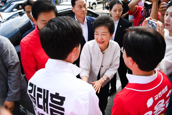 박근혜 전 대통령이 25일 오후 충남 공주의 시장에 도착해 국민의힘 김태흠 충남지사 후보 등과 악수를 나누고 있다. 김태흠 후보 캠프 제공