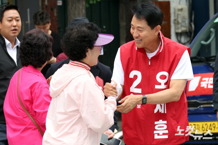 오세훈 국민의힘 서울시장 후보가 26일 서울 마포구 망원시장을 순회하며 유권자들과 만나고 있다.