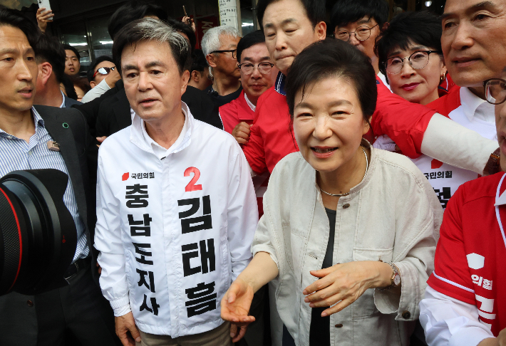  박근혜 전 대통령이 25일 오후 국민의힘 김태흠 충남지사 후보 지원 유세를 위해 충남 공주 산성시장을 찾아 상인과 시민에게 인사하고 있다. 연합뉴스