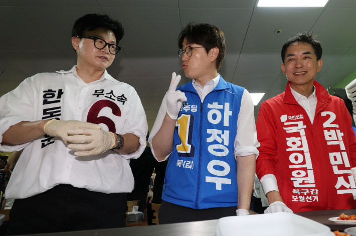 부산 북구갑 국회의원 보궐선거 한동훈 무소속 후보(왼쪽부터), 하정우 더불어민주당 후보, 박민식 국민의힘 후보가 21일 부산 남산정사회복지관에서 콩국수 나눔 봉사를 하고 있다. 부산=류영주 기자