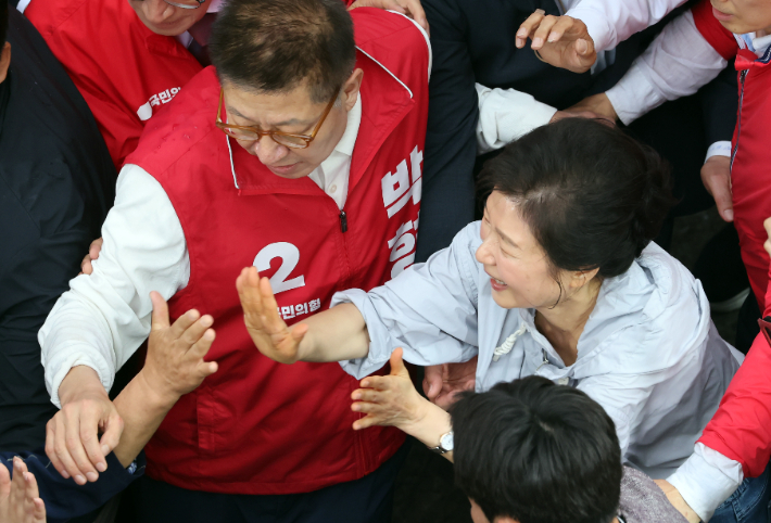 박근혜 전 대통령이 27일 오후 부산 기장군 기장시장을 찾아 국민의힘 박형준 부산시장 후보와 박민식 북갑 보궐선거 후보와 함께 시민들과 인사하고 있다. 연합뉴스