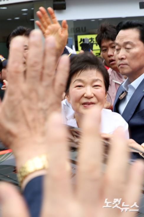 박근혜 전 대통령이 27일 강원도 원주시 중앙시장 방문을 마치고 떠나며 손을 흔들고 있다.
