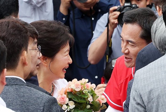  박근혜 전 대통령이 28일 강원 원주시 중앙시장을 방문해 국민의힘 김진태 강원도지사 후보로부터 꽃을 받고 있다. 연합뉴스