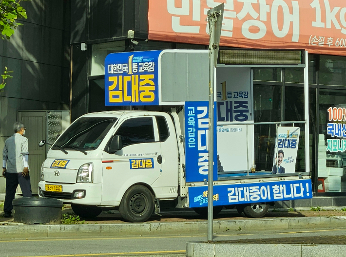 지난 25일 오후 광주 남구 월산동 대성초교 사거리 주변 인도 위를 점거하고 있는 지역 한 후보의 유세 차량. 독자 제공