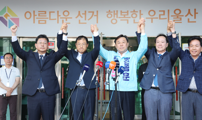 28일 울산시 중구 울산시선거관리위원회 앞에서 더불어민주당 김상욱, 진보당 김종훈 울산시장 후보가 김상욱 후보로의 단일화를 발표한 후 손을 잡고 인사하고 있다. 연합뉴스