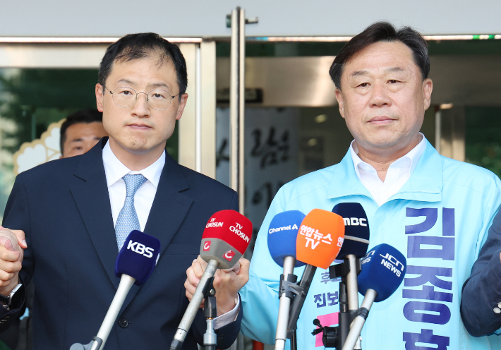  28일 울산시 중구 울산시선거관리위원회 앞에서 더불어민주당 김상욱(왼쪽), 진보당 김종훈 울산시장 후보가 김상욱 후보로의 단일화를 발표한 후 손을 잡고 있다. 연합뉴스