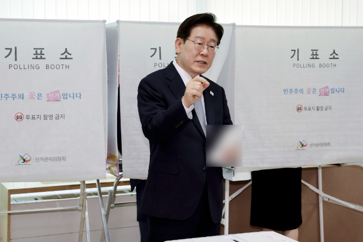 이재명 대통령이 제9회 전국동시지방선거 사전투표 첫날인 29일 서울 종로구 삼청동 주민센터에서 사전 투표 중 기표 도장 관련 문의를 하고 있다. 연합뉴스