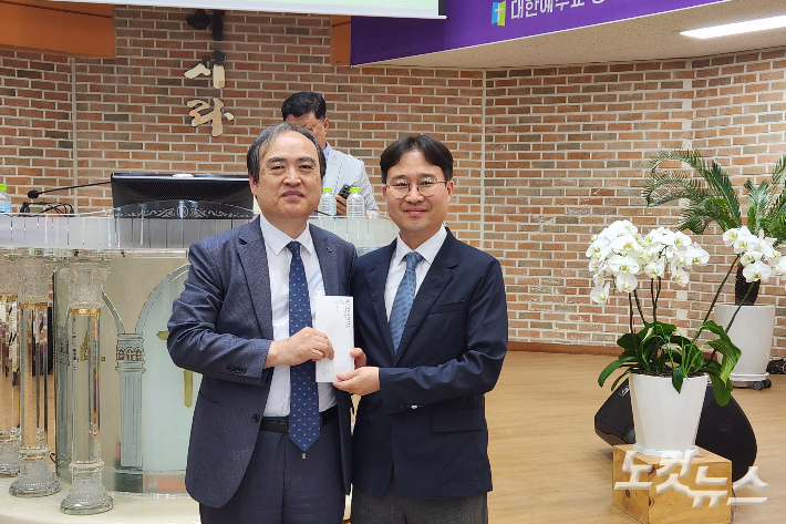 청주중앙교회 임학용 목사와 노회장 한대성 목사가 헌금 전달식을 갖고 있다, 충북CBS