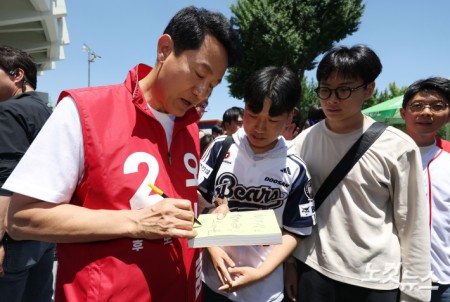오세훈 국민의힘 서울시장 후보가 31일 서울 송파구 잠실야구장을 찾아 야구팬들과 인사를 나누고 있다.