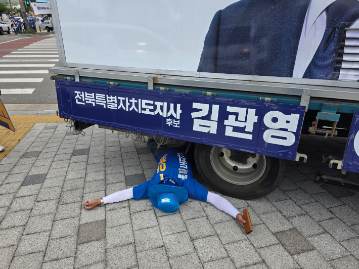 1일 오전 8시 30분쯤 전주시 완산구 효자동의 한 사거리에서 김관영 후보의 유세차량 밑에 이원택 후보 측의 선거운동원이 누워있다. 김관영 후보 캠프 제공