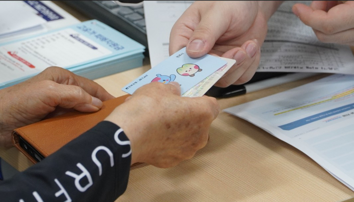 지난달 8일 전주시 서신동 주민센터에서 고유가지원금을 신청한 주민이 선불카드를 받고 있다. 기사와 직접적인 관계 없음. 심동훈 기자