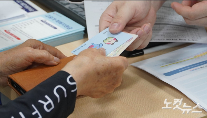 지난달 8일 전주시 서신동 주민센터에서 고유가지원금을 신청한 주민이 선불카드를 받고 있다. 기사와 직접적인 관계 없음. 심동훈 기자