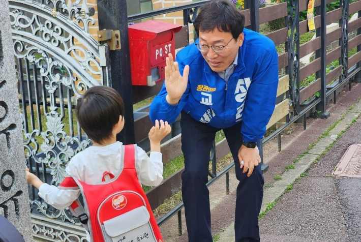 장관호 전남·광주통합특별시교육감 후보가 선거운동 마지막날인 2일 교육 정책의 절대적 기준은 아이들이라며 자신의 교육철학을 밝히고 유치원 아이와 하이파이를 하고 있다. 장 후보측 제공