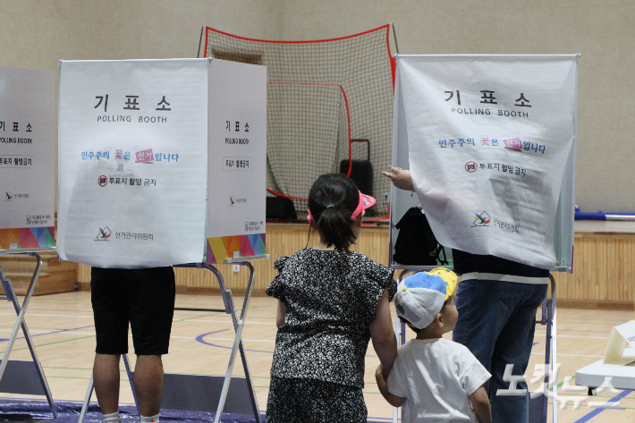 6·3 지방선거 본투표일인 3일 청주 금천고등학교 강당 투표소에서 아이들이 기표소에 들어간 부모를 기다리고 있다. 임성민 기자