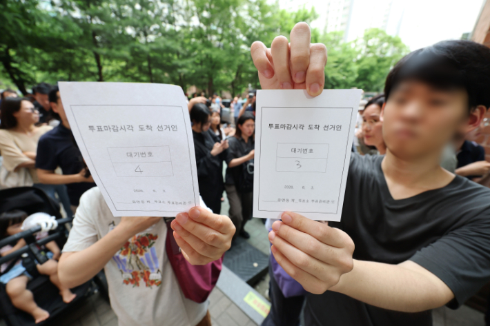 용지부족 투표 중지에 투표 대기번호표 든 유권자. 연합뉴스