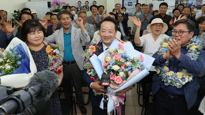 임택 더불어민주당 광주 동구청장 후보가 3일 밤 광주 동구 선거사무소에서 지지자들로부터 꽃다발을 받은 뒤 환호하고 있다. 임택 후보 캠프 제공
