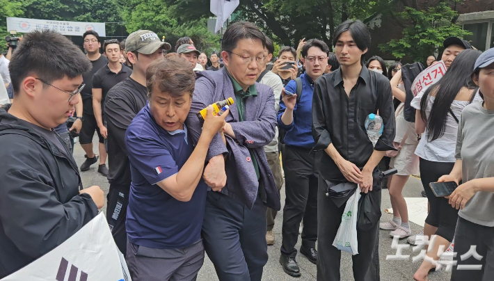 서울시선관위 김범진 사무처장이 4일 오전 서울 송파구 잠실7동 제2투표소를 찾았다가 떠나는 과정에서 시위대가 막아서는 모습. 이원석 기자