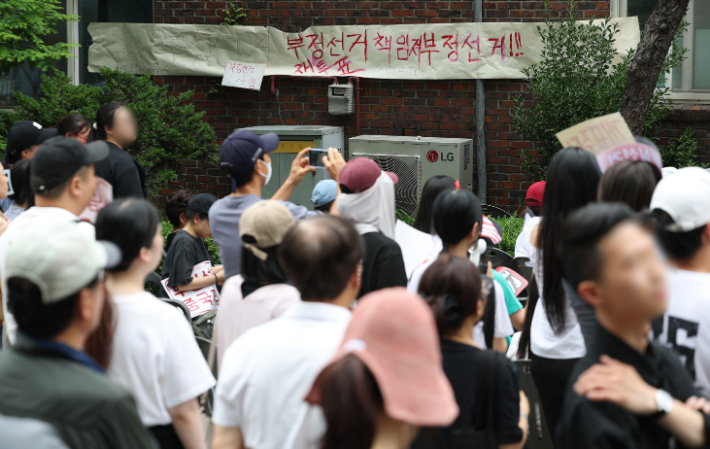 9회 전국동시지방선거 및 국회의원 재·보궐선거 투표용지 부족으로 투표 시간이 오후 10시까지 연장됐던 서울 송파구 잠실7동 제2투표소 앞에서 지난 4일 투표함 반출에 반대하는 시민들이 모여 있는 모습. 연합뉴스
