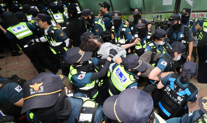 5일 서울 송파구 잠실7동 2투표소 앞에서 경찰이 투표함 이송을 위해 이를 막아선 시위대를 해산 조치하고 있다. 연합뉴스