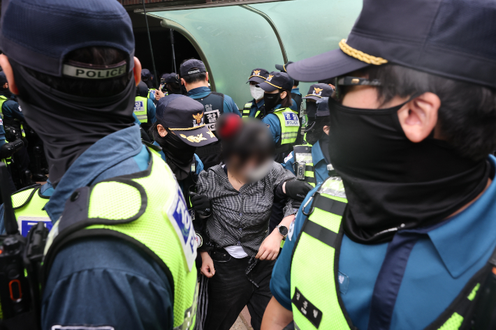 5일 서울 송파구 잠실7동 2투표소 앞에서 경찰이 투표함 이송을 위해 이를 막아선 시위대를 해산 조치하고 있다. 연합뉴스