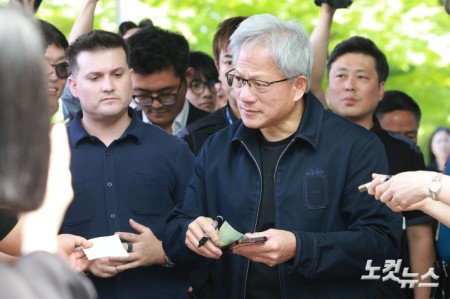 젠슨 황 엔비디아 최고경영자(CEO)가 5일 오후 서울 강서구 서울김포비즈니스항공센터를 통해 입국해 팬이 건낸 만원 지폐에 사인을 하고 있다.