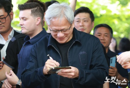 젠슨 황 엔비디아 최고경영자(CEO)가 5일 오후 서울 강서구 서울김포비즈니스항공센터를 통해 입국해 팬이 건낸 만원 지폐에 사인을 하고 있다.