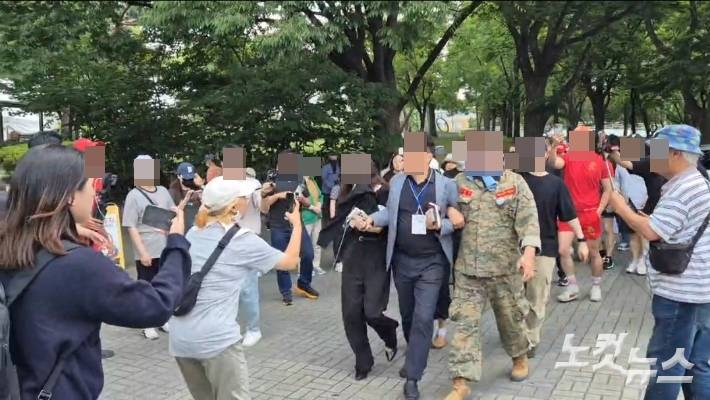 5일 송파구 개표소 앞에서 '부정선거'를 주장하는 시위대 일부 참가자들이 참관인을 붙잡아 데려오는 모습. 송선교 기자 