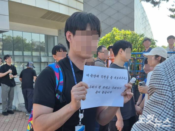 개표소가 마련된 올림픽공원 핸드볼경기장에서 일하는 한 체육단체 직원은 피켓을 보여주며 시위대 설득에 나섰다. 김지은 기자