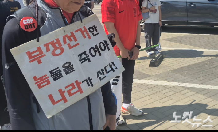 6일 오전 서울 송파구 올림픽공원 핸드볼경기장 앞에서 재선거 실시를 요구하는 집회에 참석한 한 시민 모습. 주보배 기자  