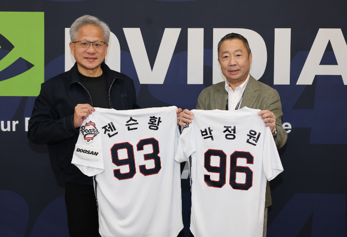 7일 잠실야구장을 방문한 박정원 두산그룹 회장(오른쪽)과 젠슨 황 엔비디아 CEO가 등번호 96번과 93번이 적힌 두산 베어스 유니폼을 들고 기념사진을 촬영하고 있다. 두산그룹 제공