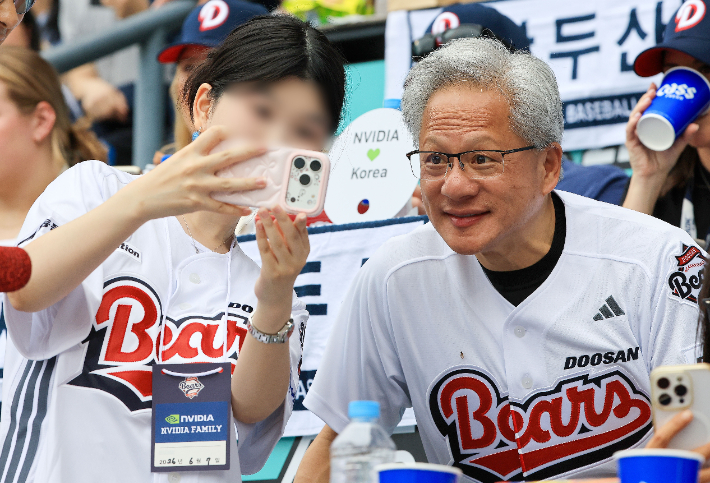 젠슨 황 엔비디아 최고경영자(CEO)가 7일 서울 잠실야구장에서 열린 2026 프로야구 KBO리그 키움 히어로즈와 두산 베어스의 경기를 관람하며 팬들과 기념사진을 촬영하고 있다. 연합뉴스