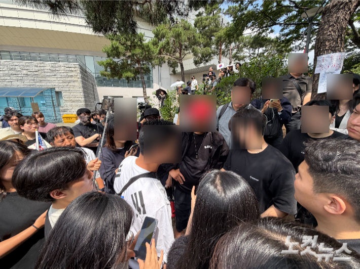 8일 집회 참가자들이 한 20대 남성을 둘러싸며 해명을 요구하고 있따. 박인 기자 